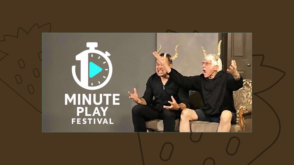 An image of two men performing a play on stage wearing funny horns and shouting. To the left of them is a logo for the "One Minute Play Festival"